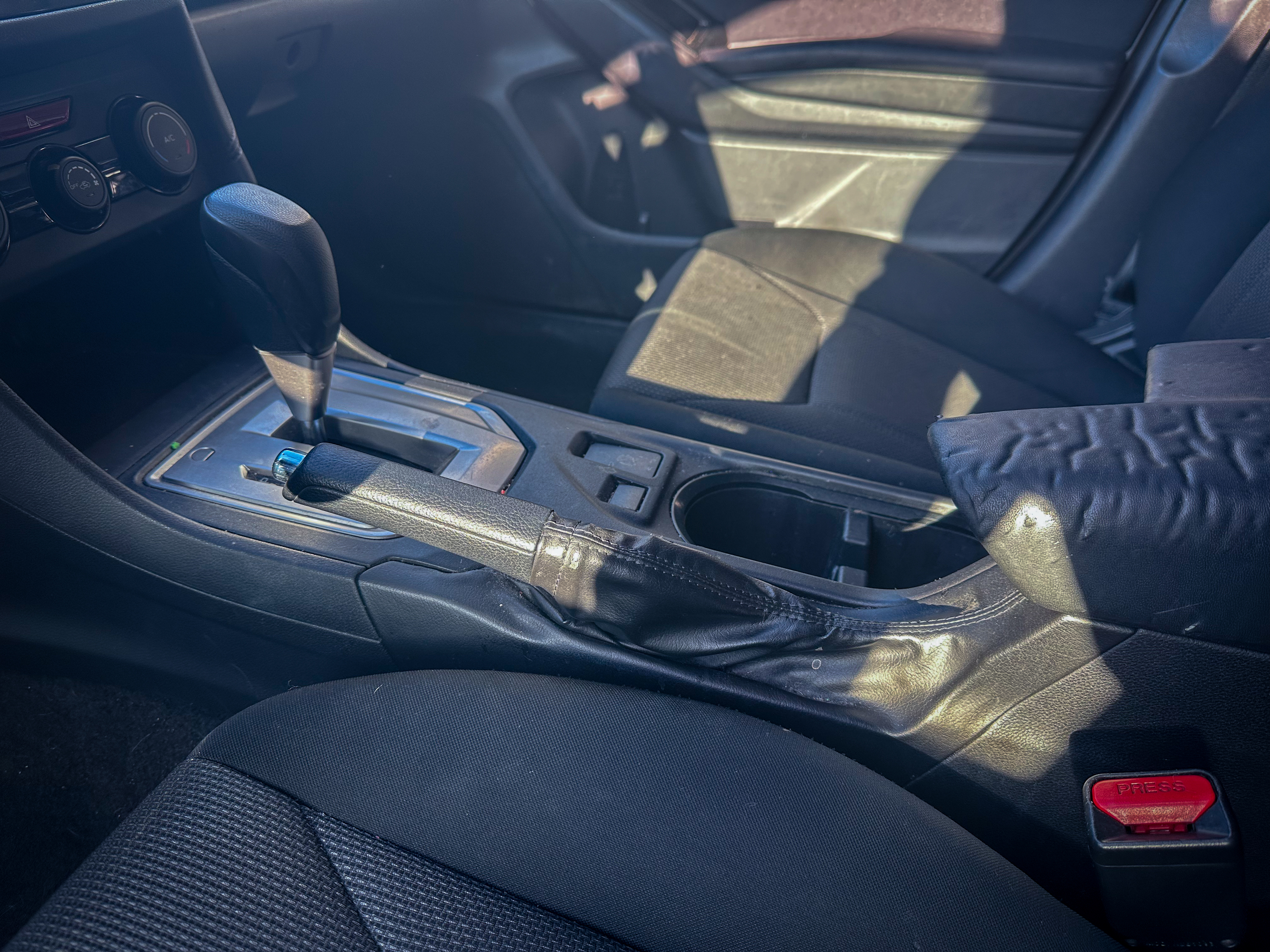 A photo of the Subaru Crosstrek parking brake lever in its off position, located in the center console