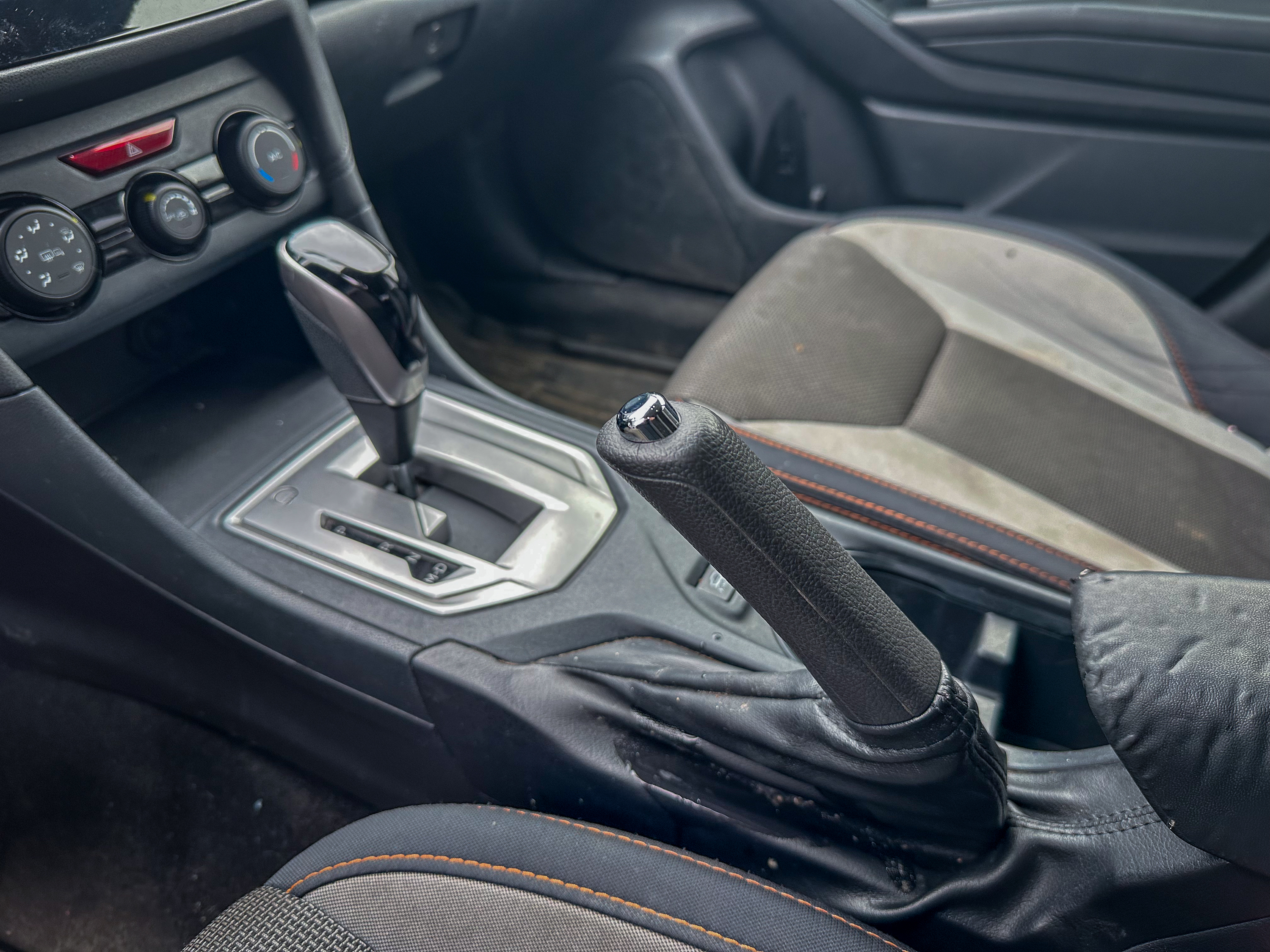 A photo of the Subaru Crosstrek parking brake lever in its on position, located in the center console